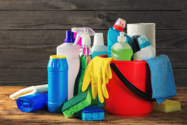 Basket with variety cleaning product on wooden table, close up