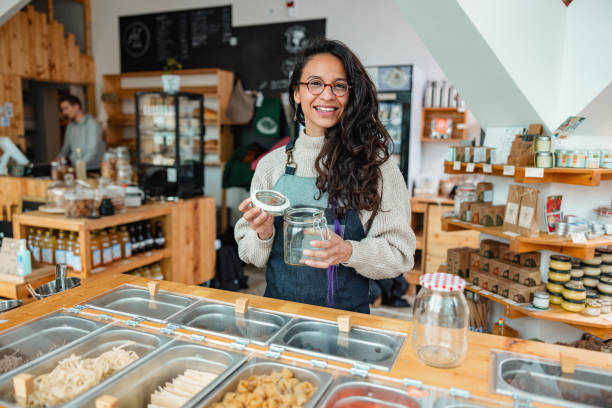 Smiling female in a zero waste shop holding a jar