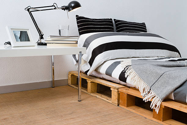 Recycled DIY pallet platform bed in modern bedroom. Upcycling ideas.