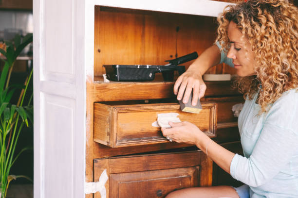 Shabby chic renovating and upcycling antique old cabinet furniture to home kitchen improvement. One woman working with hands in indoor happy leisure job activity repairing and working. upcycling ideas.