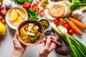 Essential vegan nutrients. Vegetables, hummus, pesto and lentil curry with tofu.